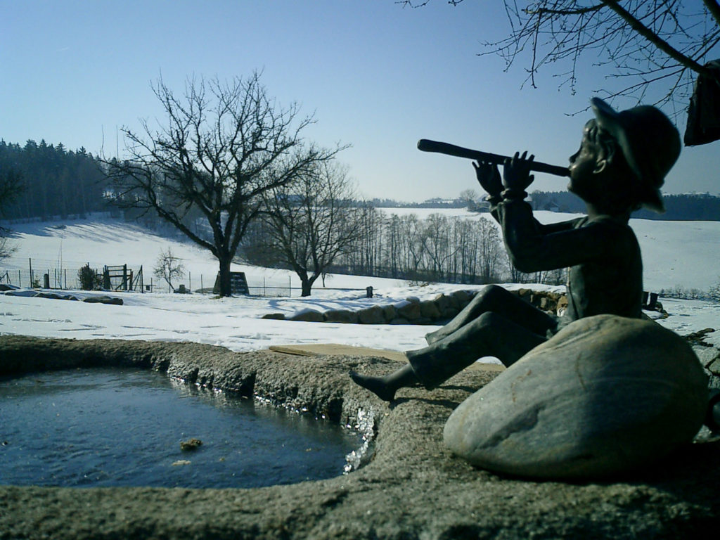 FREIRAUM Steinbrunnen mit Figur im Winter
